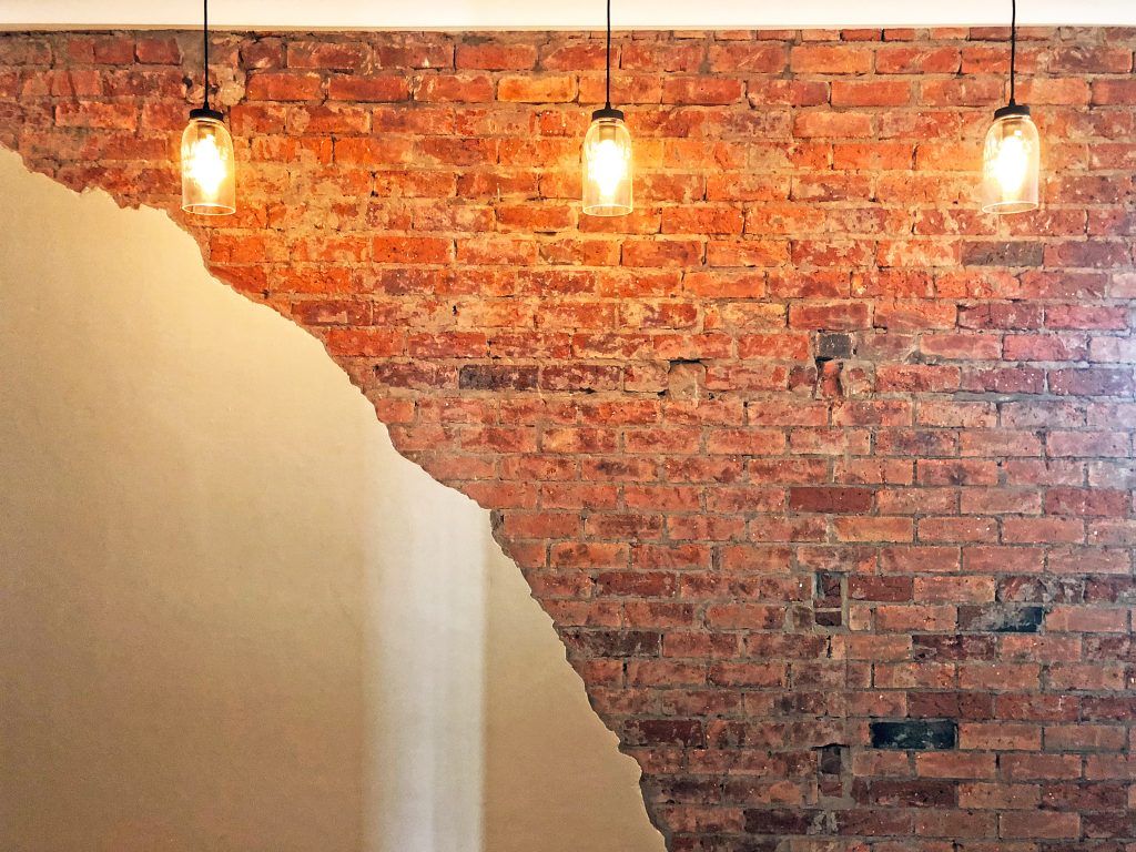 Exposed red brick feature wall with hanging Edison pendant lights