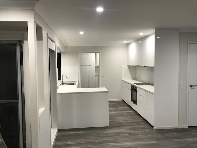 Open-plan kitchen with island bench and timber-look flooring