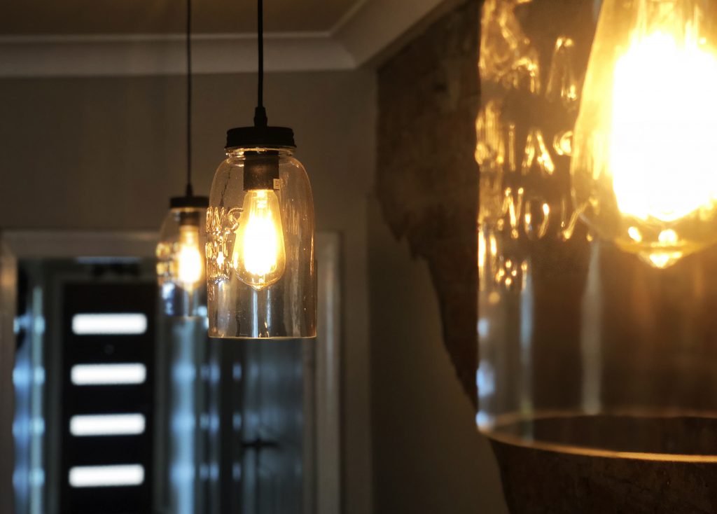 Glass pendant lighting against a dark feature wall