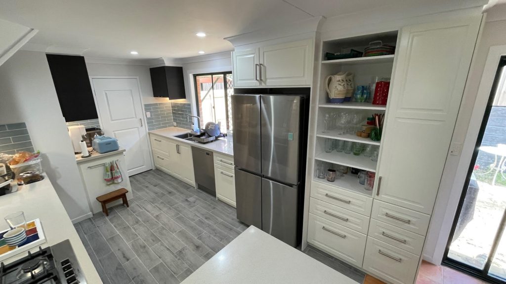 Kitchen with stone benchtop, open shelving and integrated fridge